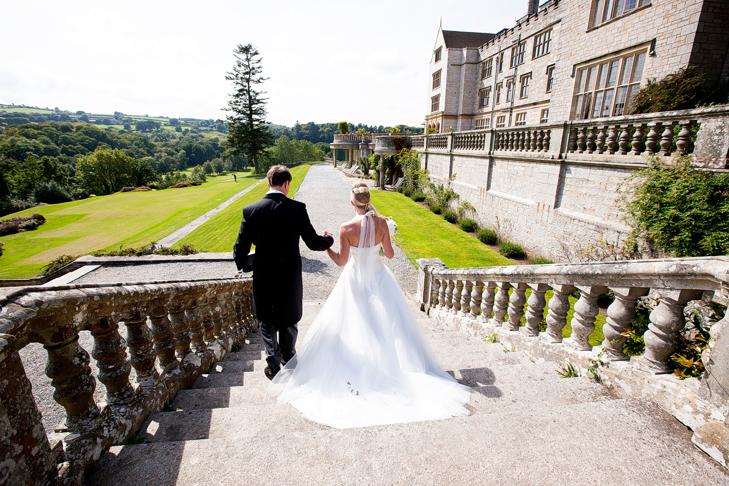 Bride & Groom walking down the steps into the incredible grounds of Bovey Castle. 