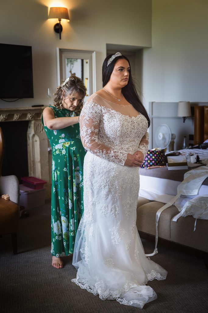 The Gorgeous, but nervous, bride getting into her stunning wedding dress at the De Vere Beaumont Estate in Windsor.