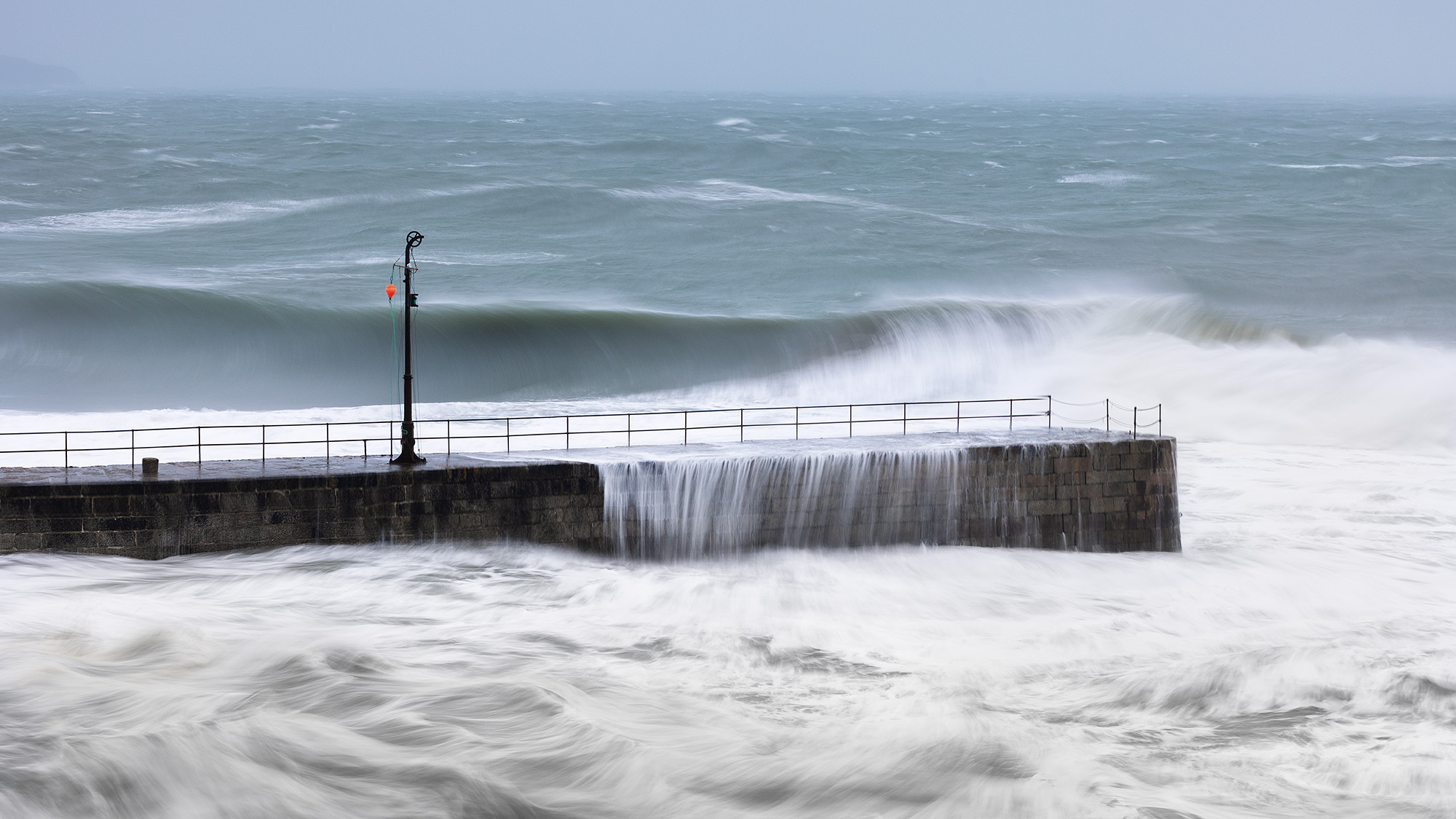 Trying to get creative by slowing down the shutter speed as the waves fall away from the pier.